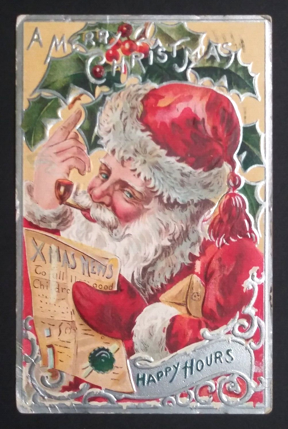 A Merry Christmas Happy Hours Santa w/ Pipe Reading News Embossed Postcard 1908