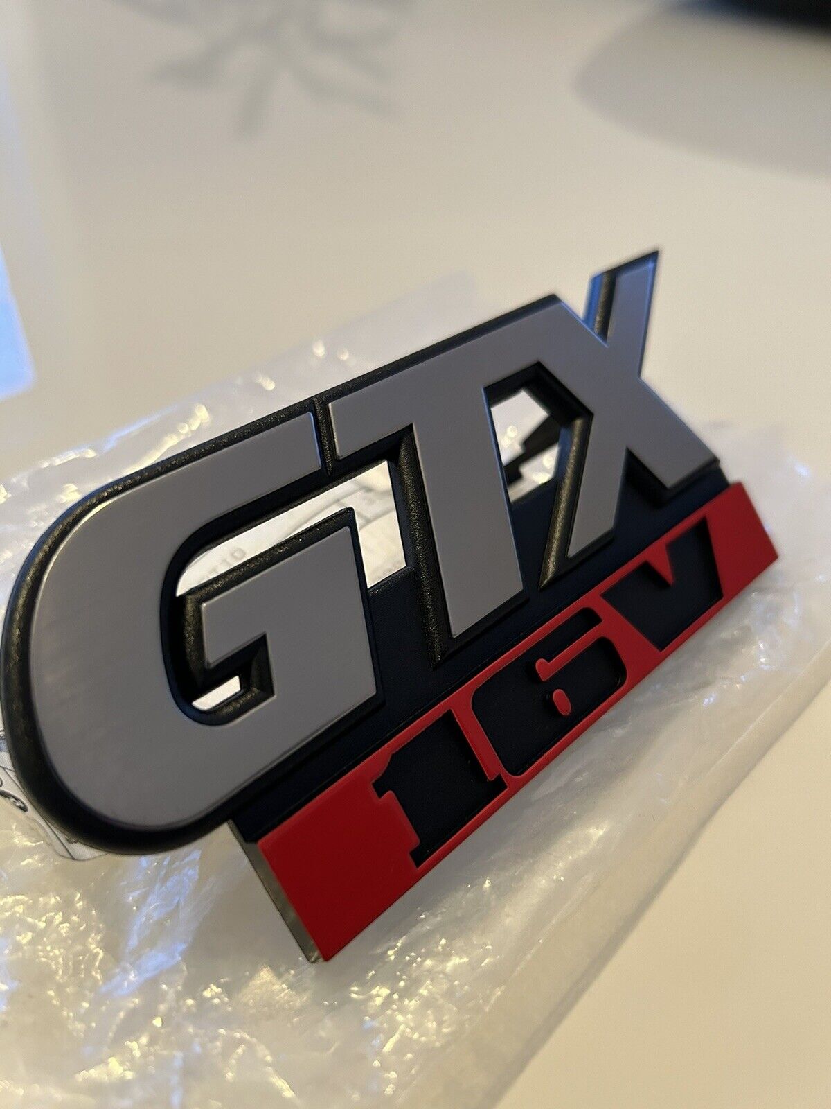 VW GTX 16V front grille badge. OEM NOS new in bag. Very rare