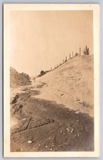 Dirt Road Tracks Running Through Deep Earthen Cut With Fence On Ridge Scene RPPC picture