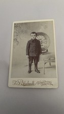 Little Boy In A Suit Standing Next To A Chair Antique Cabinet Photo picture