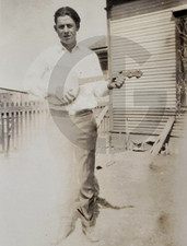 Man Playing a Banjo by a Farm Building: 1920's Snapshot Photo picture