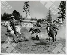 1961 Rodeo event with a man on a horse trying to lasso a bull picture