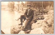 Scenic Landscape centered by Suited Man on Shoreline Rock, in Spirit Lake Iowa picture