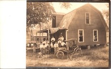 THIRTEEN PEOPLE ON FRONT PORCH OF HOUSE :AMERICAN FLAG :OLD CAR : RPPC 1904-1918 picture
