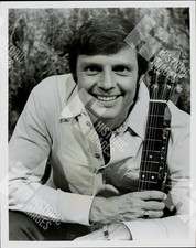 1970 Portrait of a smiling man holding a guitar picture