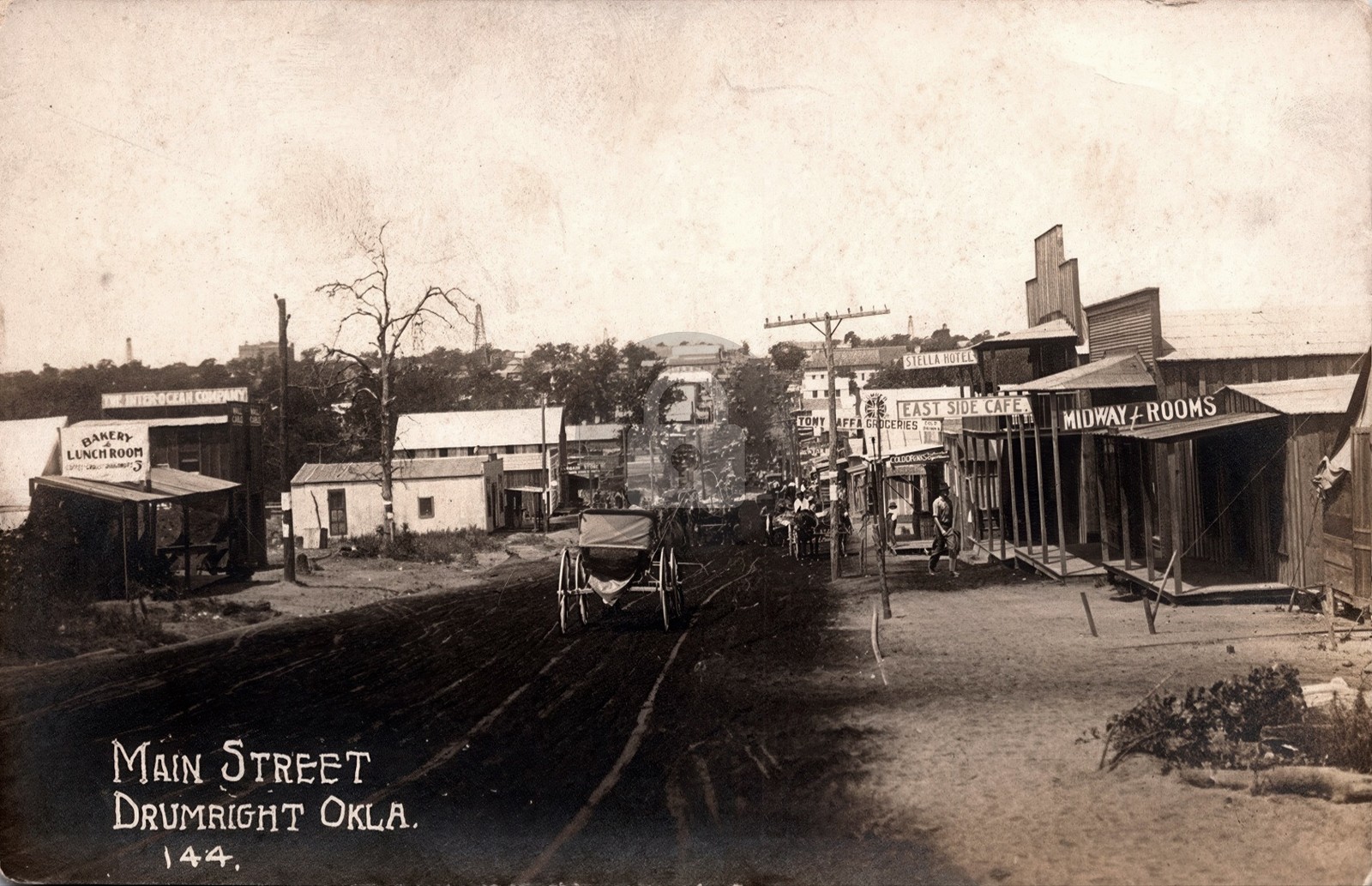 Drumright OK Main Street Busy Business Dist. Signs Wagons RPPC Postcard COPY