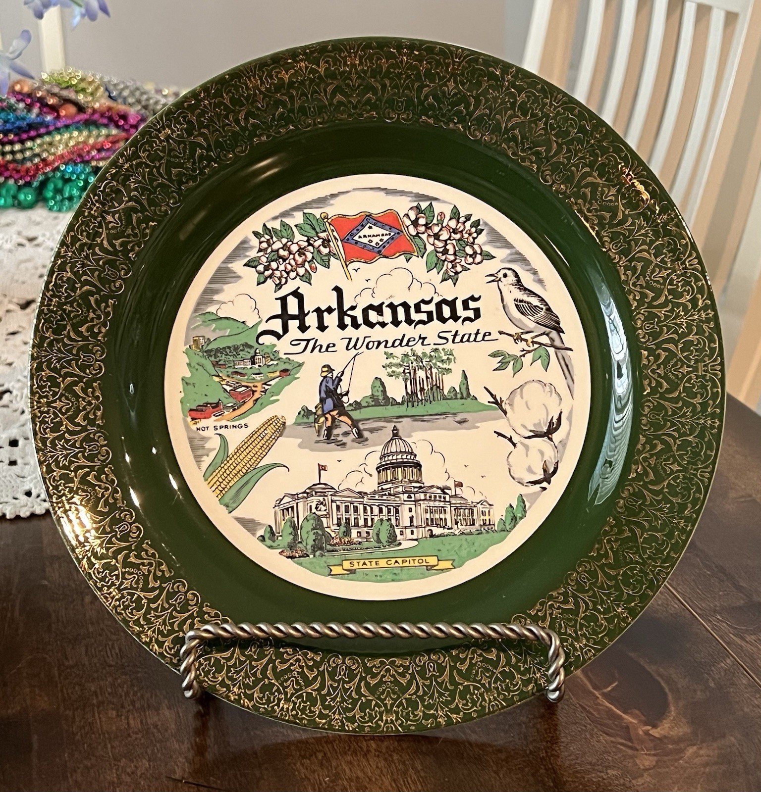 Vintage green and gold plate featuring Arkansas state landmarks.