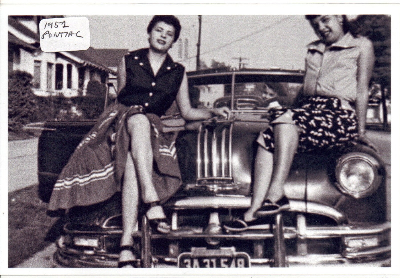 Two Ladies Sitting on a 1952 Pontiac Photo