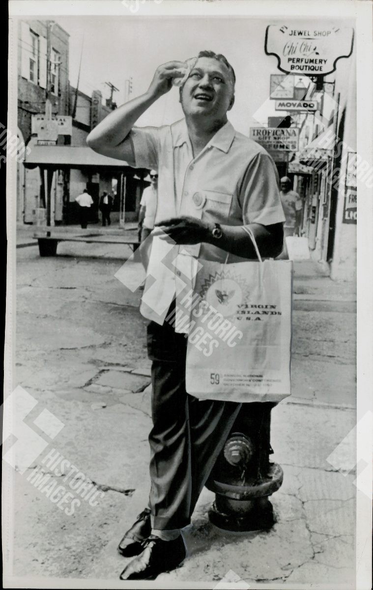 1967 Alaska Governor Walter J. Hickel posing in a street with a shopping bag