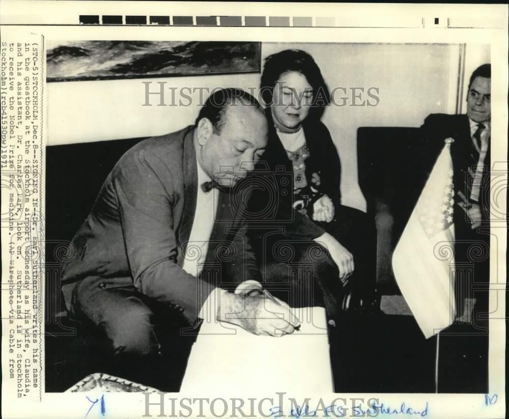 1971 Press Photo Dr. Earl Sutherland signs book at Stockholm, Sweden airport