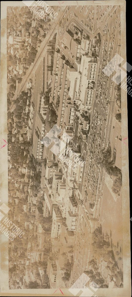 1911 An aerial view of a campus with multiple buildings and a large parking lot