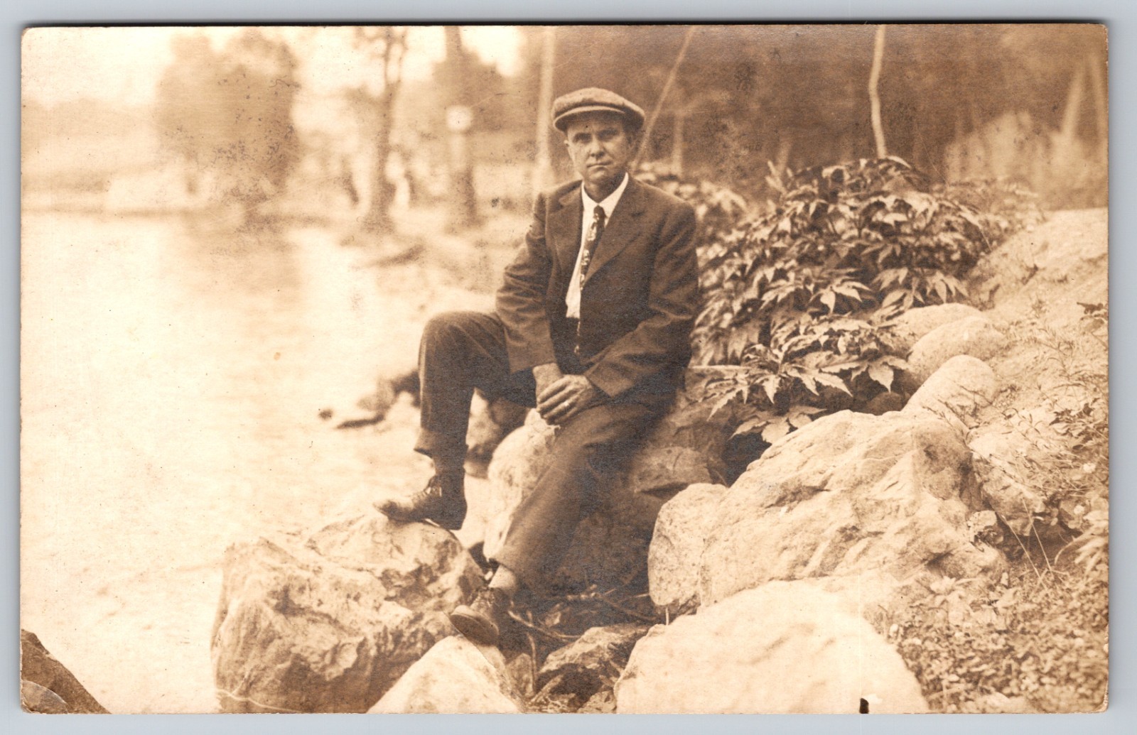 Scenic Landscape centered by Suited Man on Shoreline Rock, in Spirit Lake Iowa