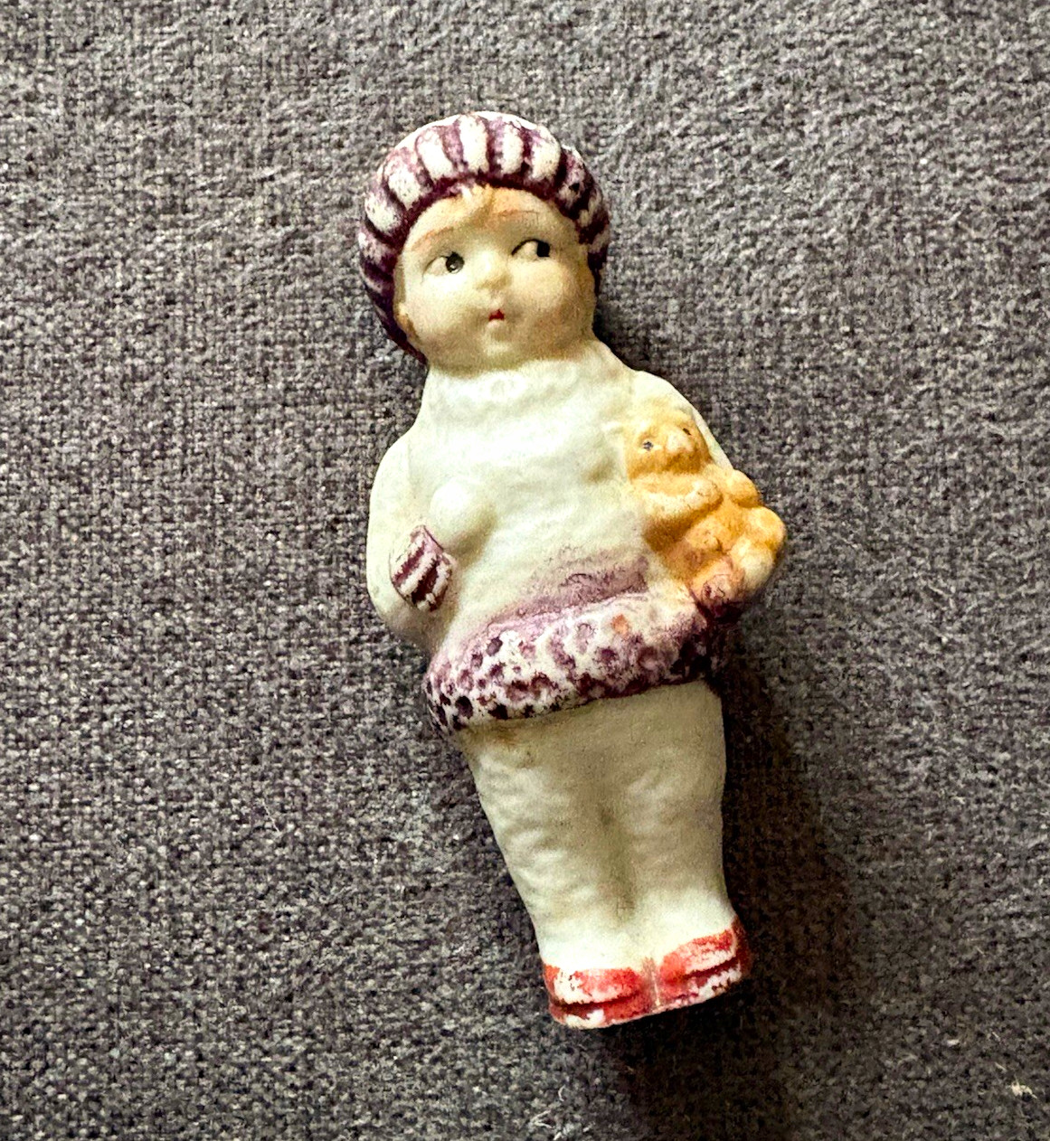 Vintage 1920s painted bisque porcelain penny doll holding teddy bear