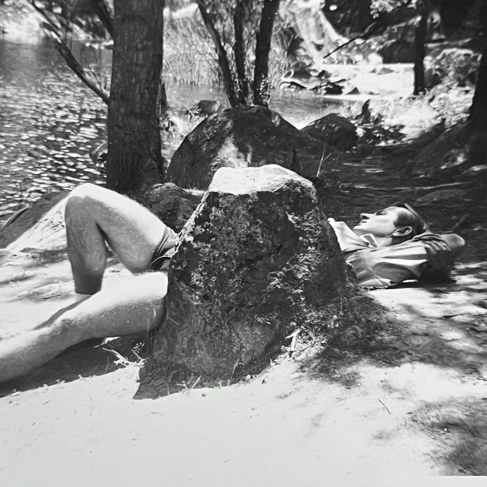 Vintage B&W Snapshot Photograph Handsome Man Laying Outside Behind Rock Shorts