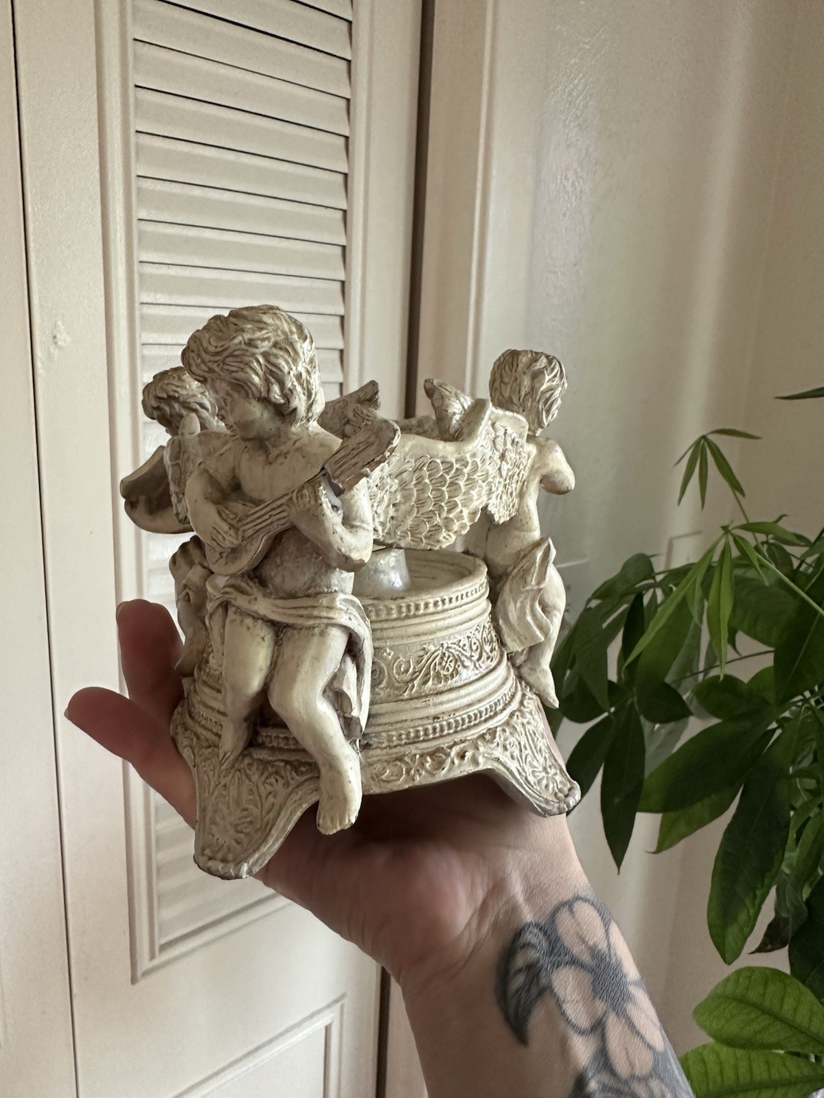 Vintage gold-toned resin candle holder featuring three cherub musicians