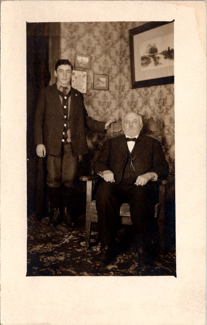 Young Man Standing Older Man Seated Full Length Postcard Real Photo RPPC