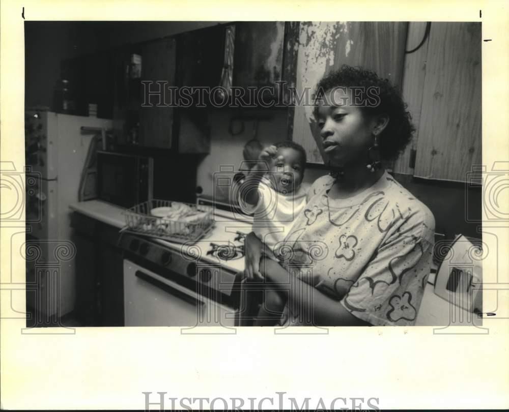 1992 Press Photo Tanya Creecy holds her son as she speaks about burnt cabinet