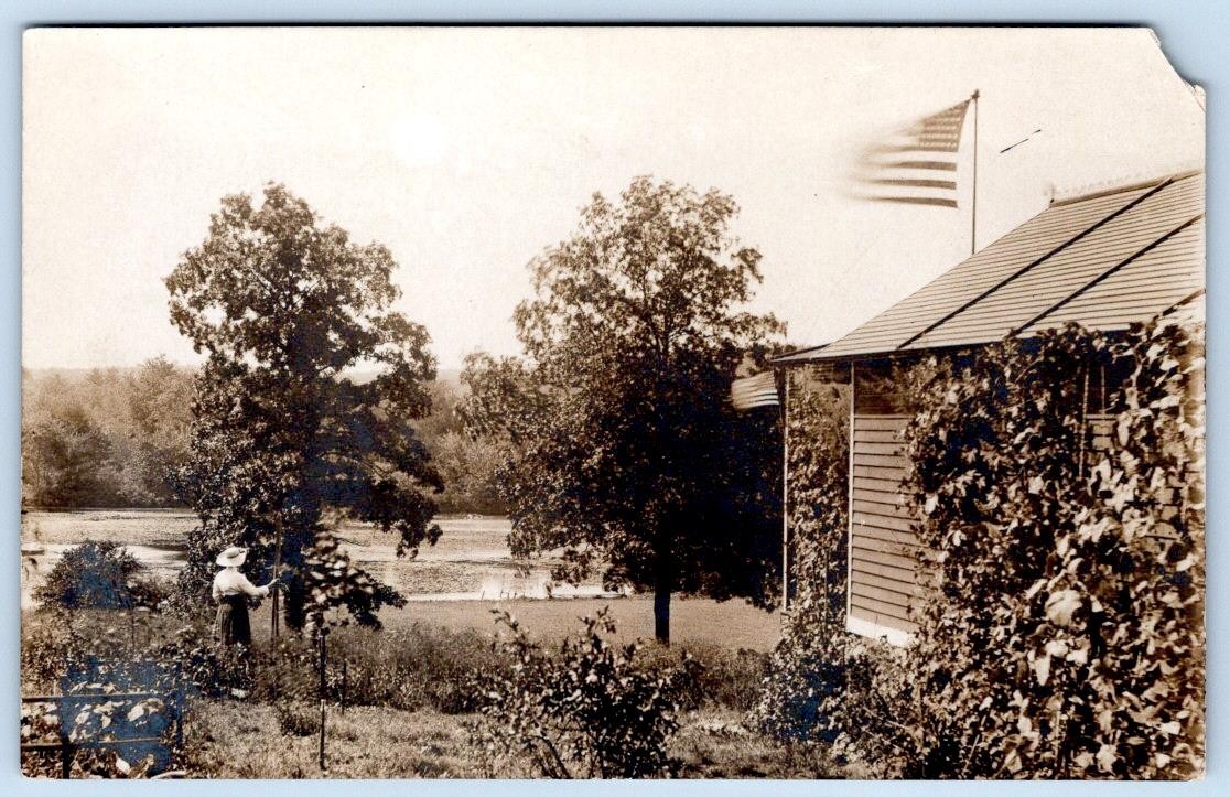 1907-10's RPPC AMERICAN FLAGS WOMAN IN GARDEN HOUSE LAKE PATRIOTIC POSTCARD