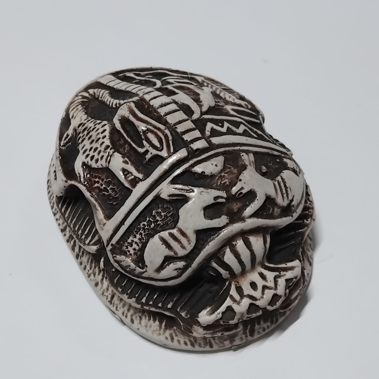 Ancient Egyptian scarab stone carving, black and white, hieroglyphic details