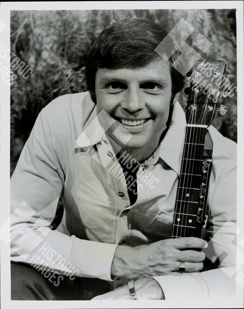 1970 Portrait of a smiling man holding a guitar