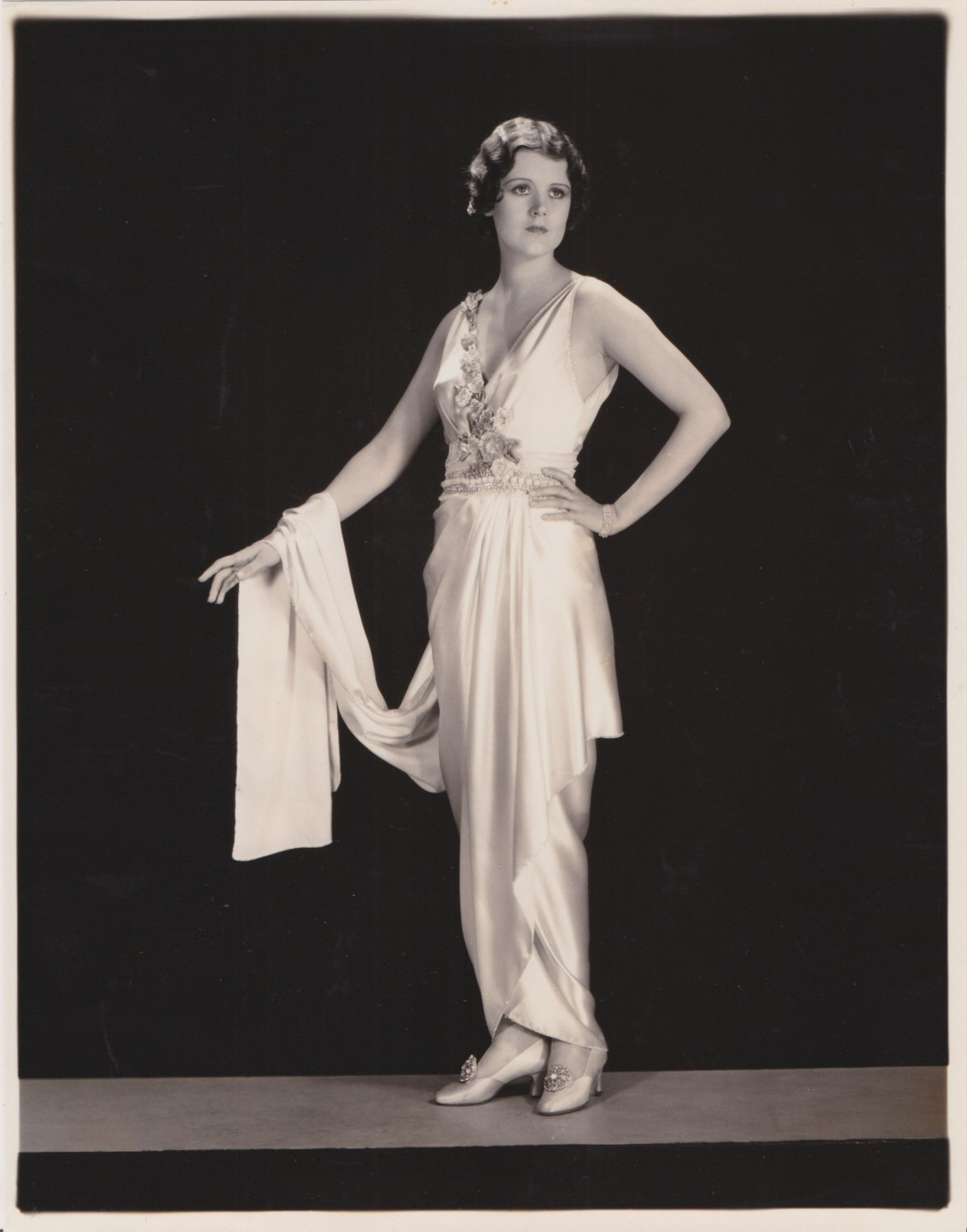 1930 Press Photo Actress June Collyer models draped gown of white satin crystals